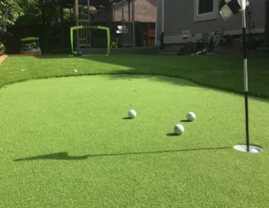 artificial turf putting green showing golf balls and hole with flag